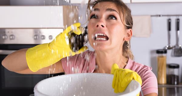 Woman With Water Leaking From Ceiling